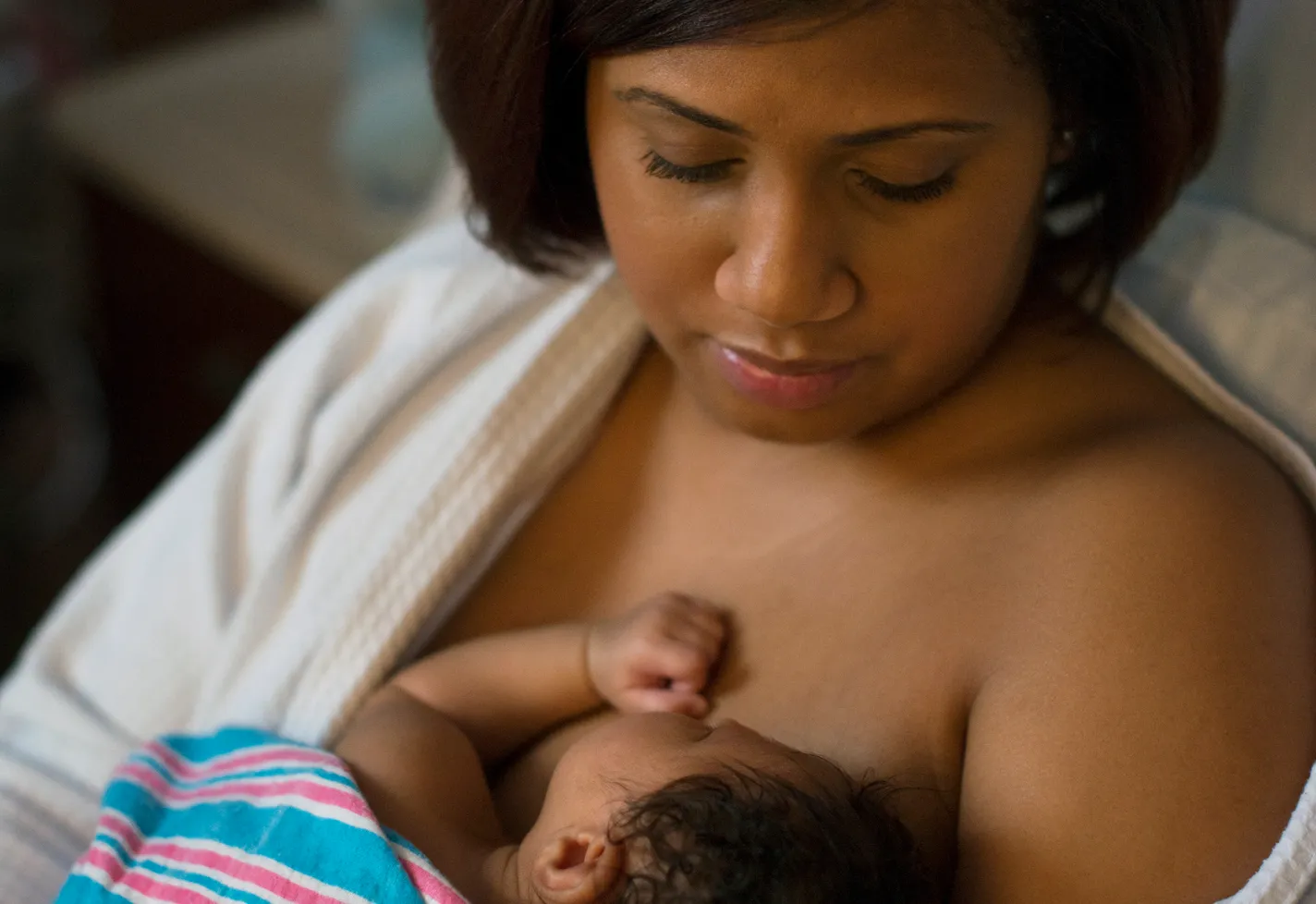 A mother practicing skin-to-skin contact with her newborn. A mother practicing skin-to-skin contact with her newborn.