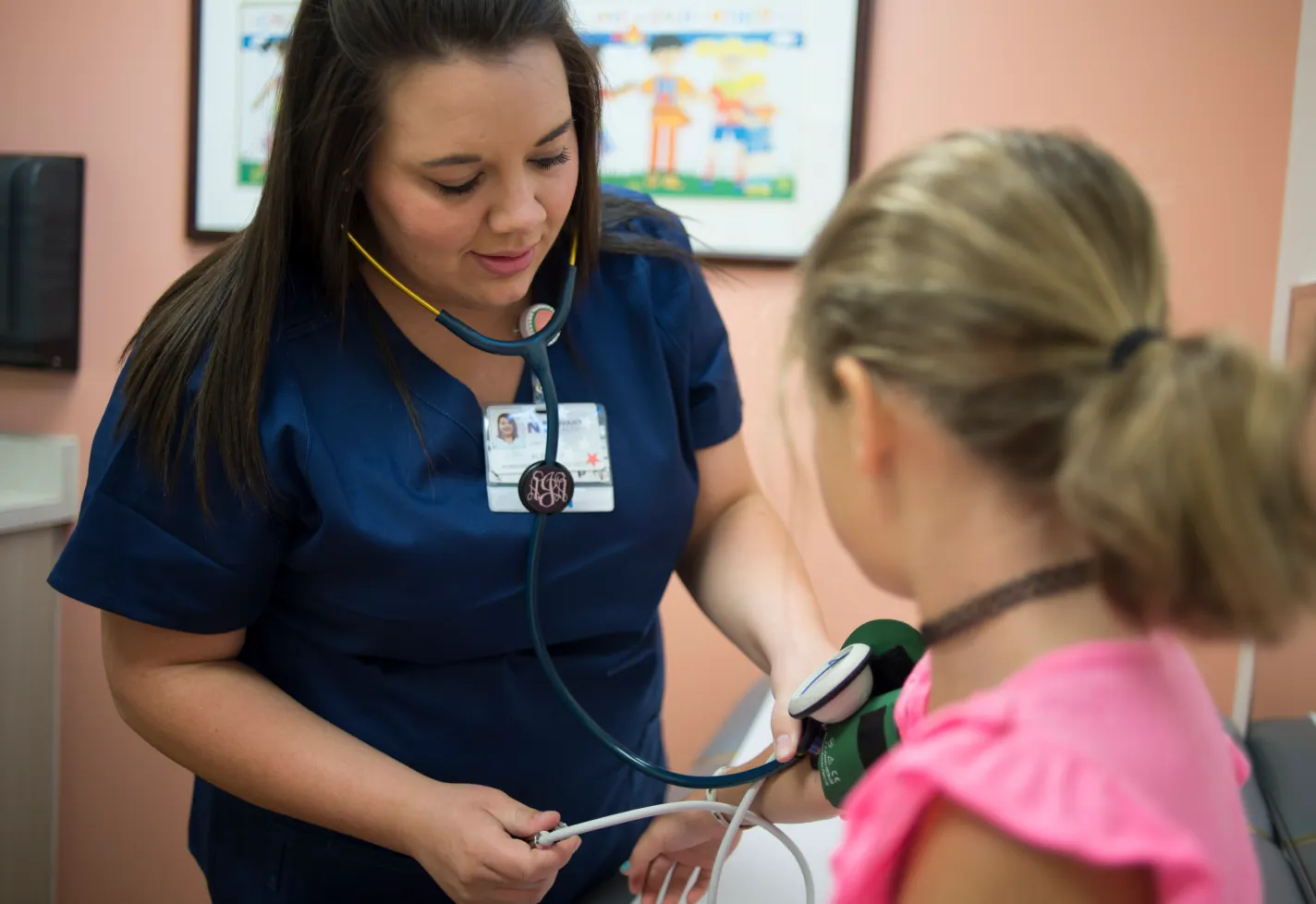 A Novant Health nurse is taking a young girls blood pressure. 