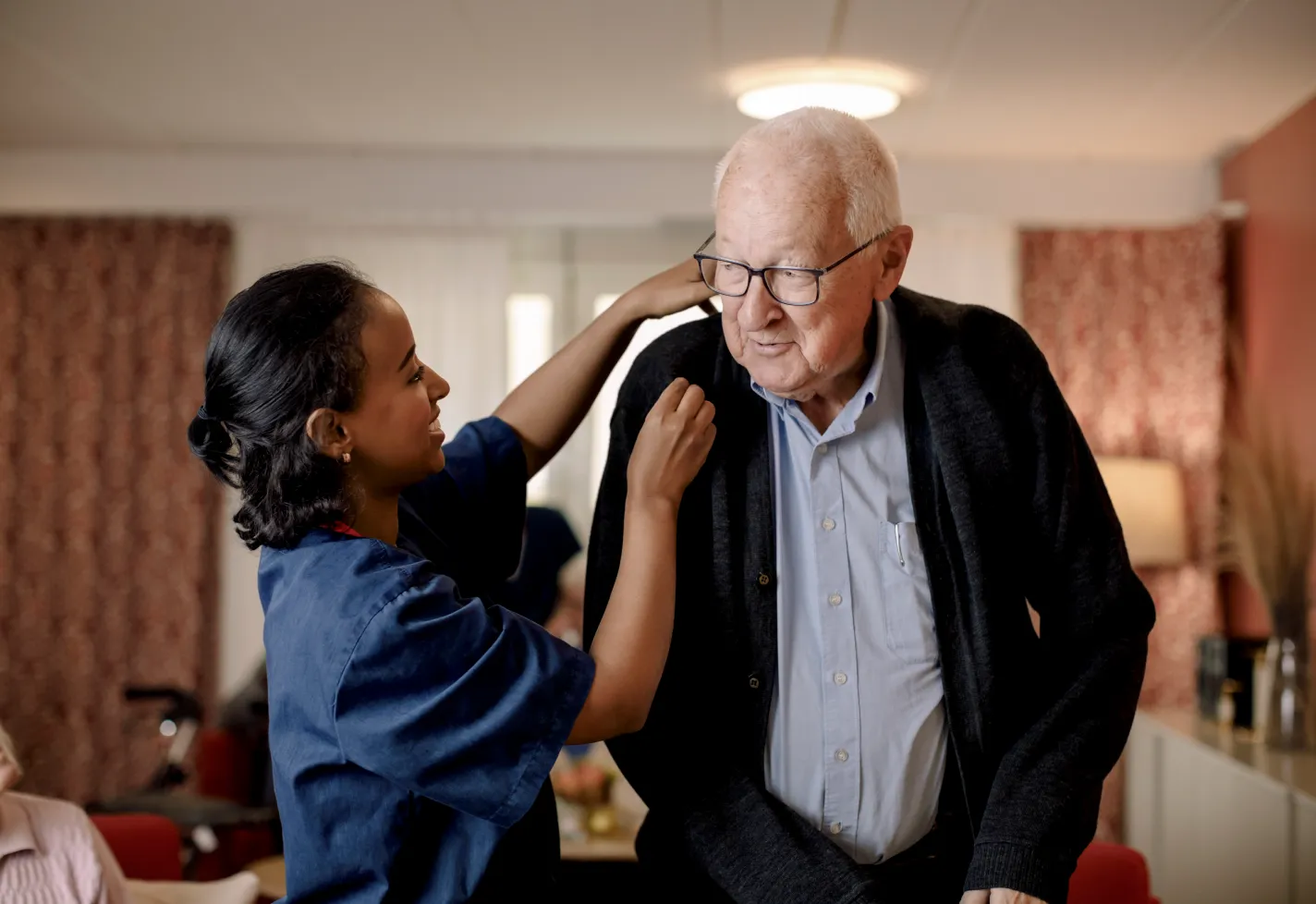 Nurse with a senior man in his home. The nurse is assisting the man as he stands. Nurse with a senior man in his home. The nurse is assisting the man as he stands.