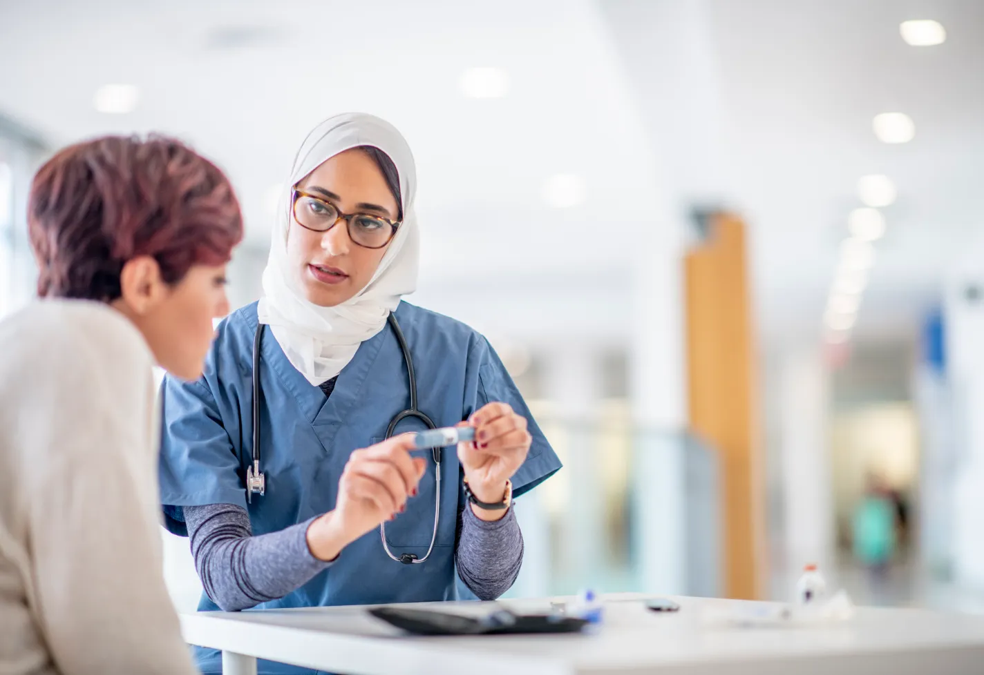 A nurse is talking with and explain medication details to a patient. A nurse is talking with and explain medication details to a patient.
