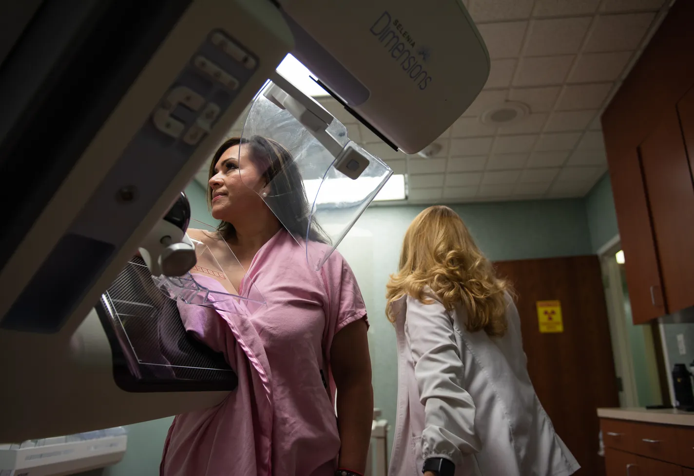 Woman having a mammography examination at a clinic with a female technician.