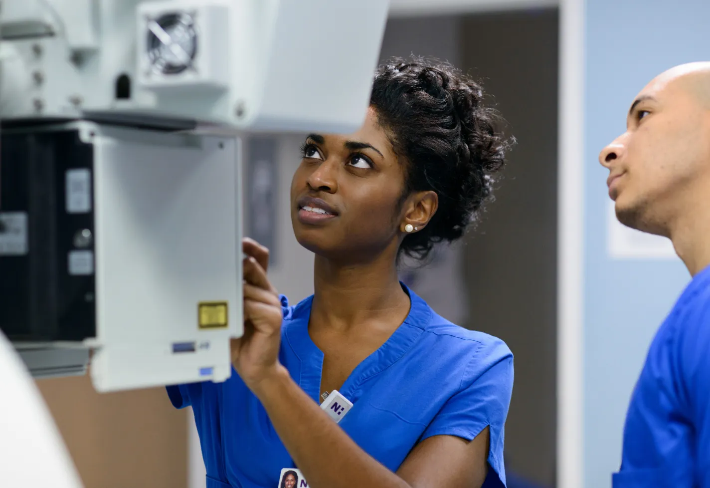 A Novant Health team member is operating a machine to capture an patients imaging scan. 