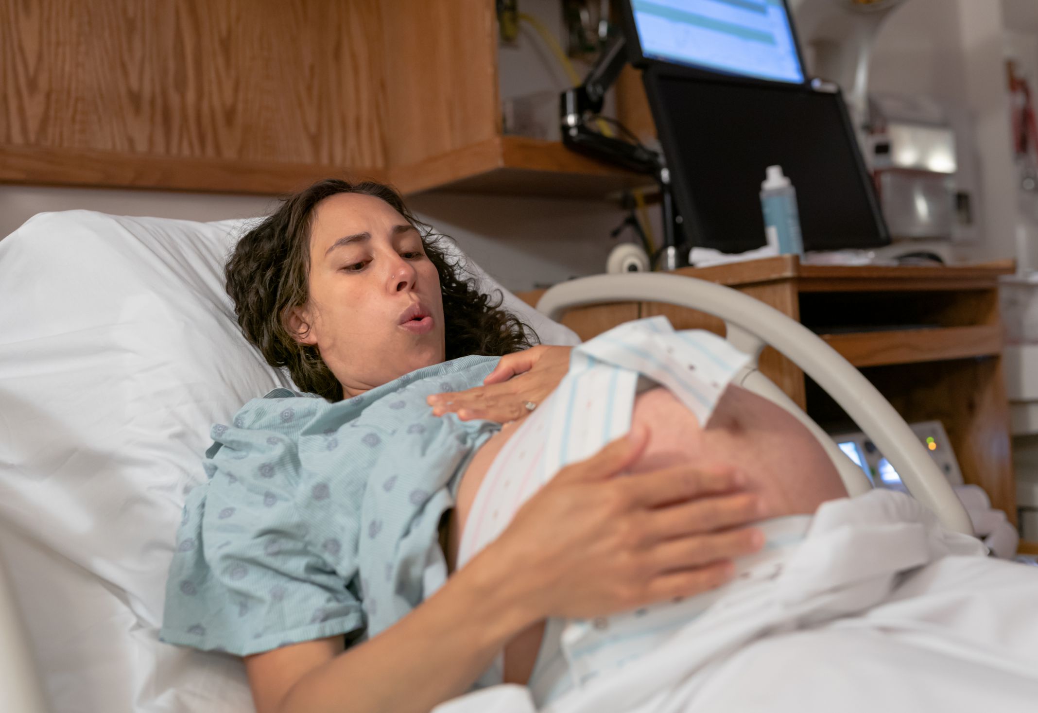 Mom in Novant Health labor & delivery suite doing breathing exercises Mom in Novant Health labor & delivery suite doing breathing exercises