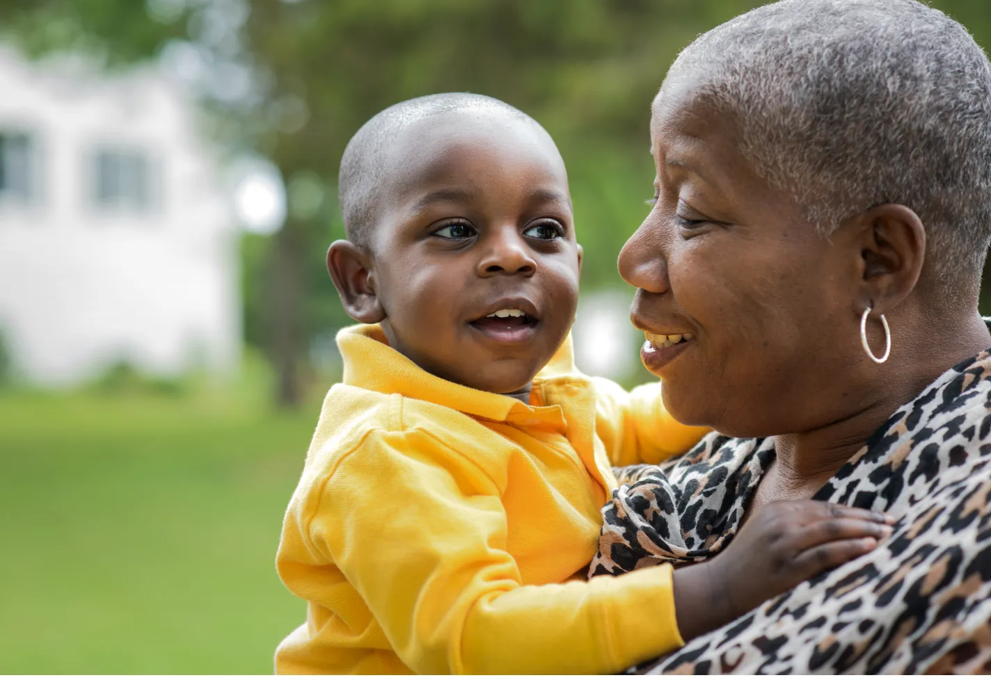 Grandmother holding baby grandson in her arms and smiling