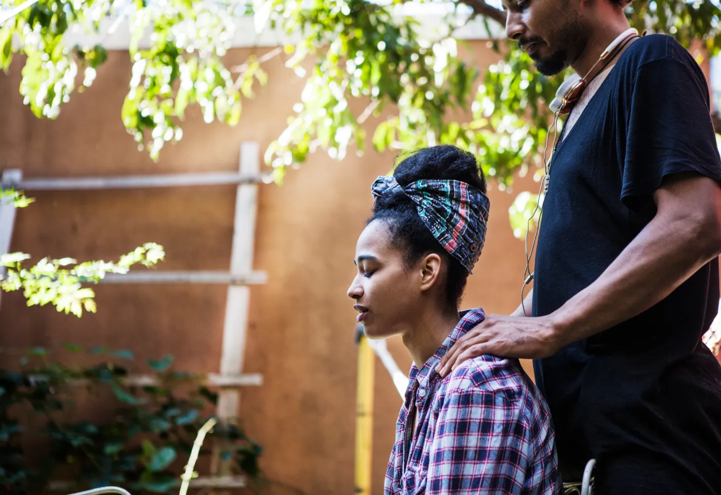Man giving a woman a shoulder massage outdoors Man giving a woman a shoulder massage outdoors