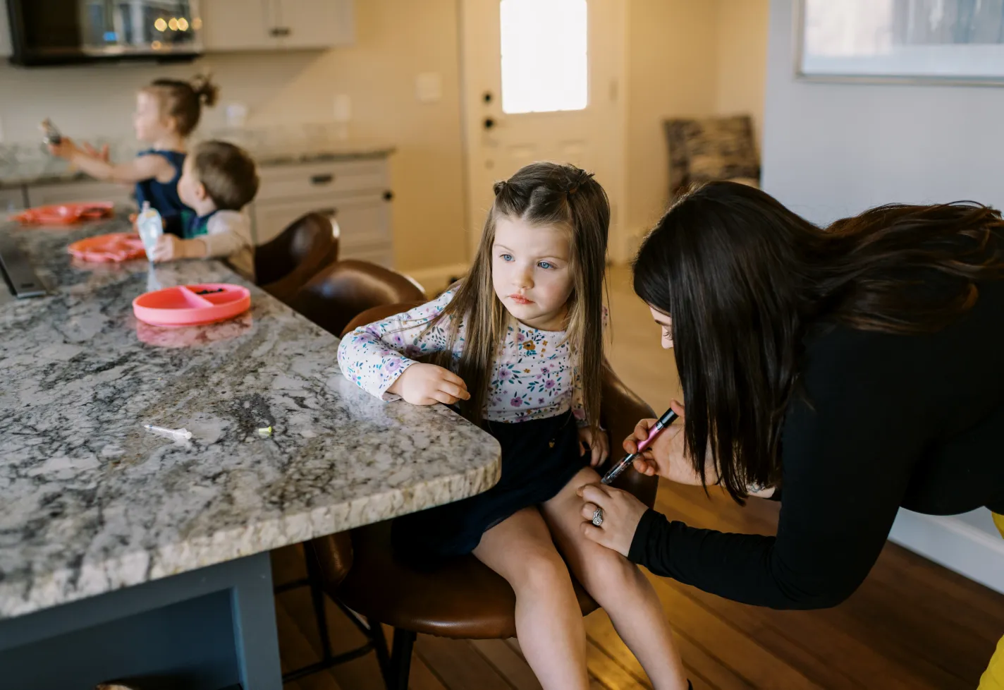 Young child getting an insulin injection from her mother