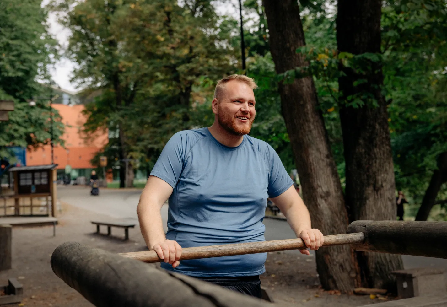 A man is smiling as he works out outdoors. 