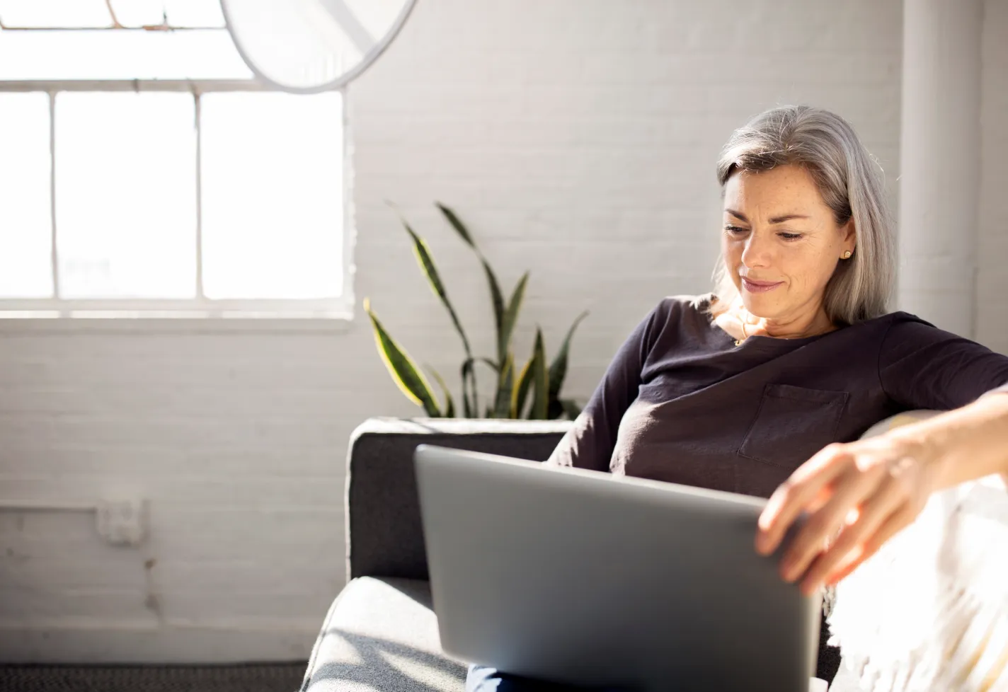 Woman using her laptop computer on the couch Woman using her laptop computer on the couch