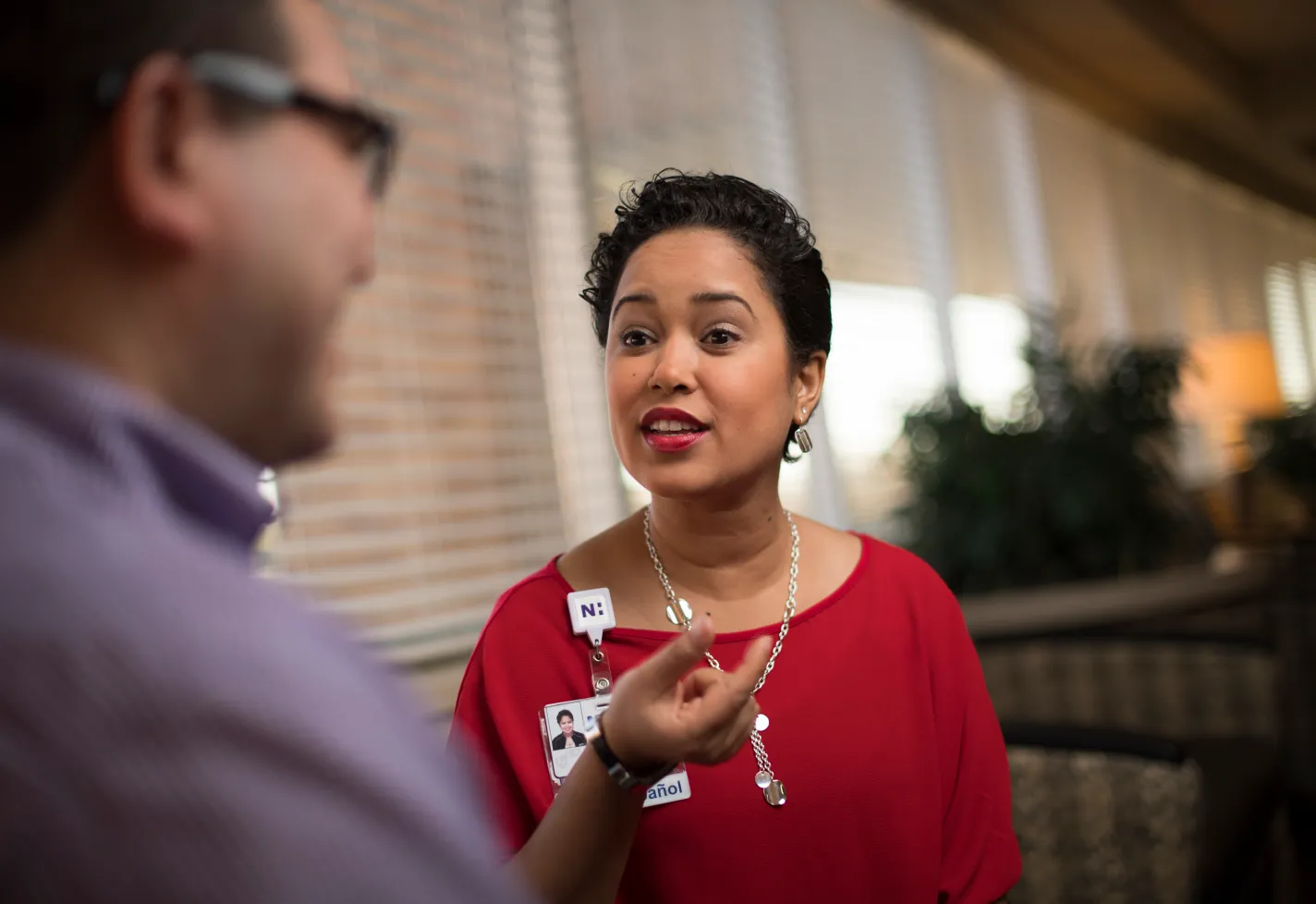 A Novant Health team member is interpreting for a male patient in the lobby of a clinic. 