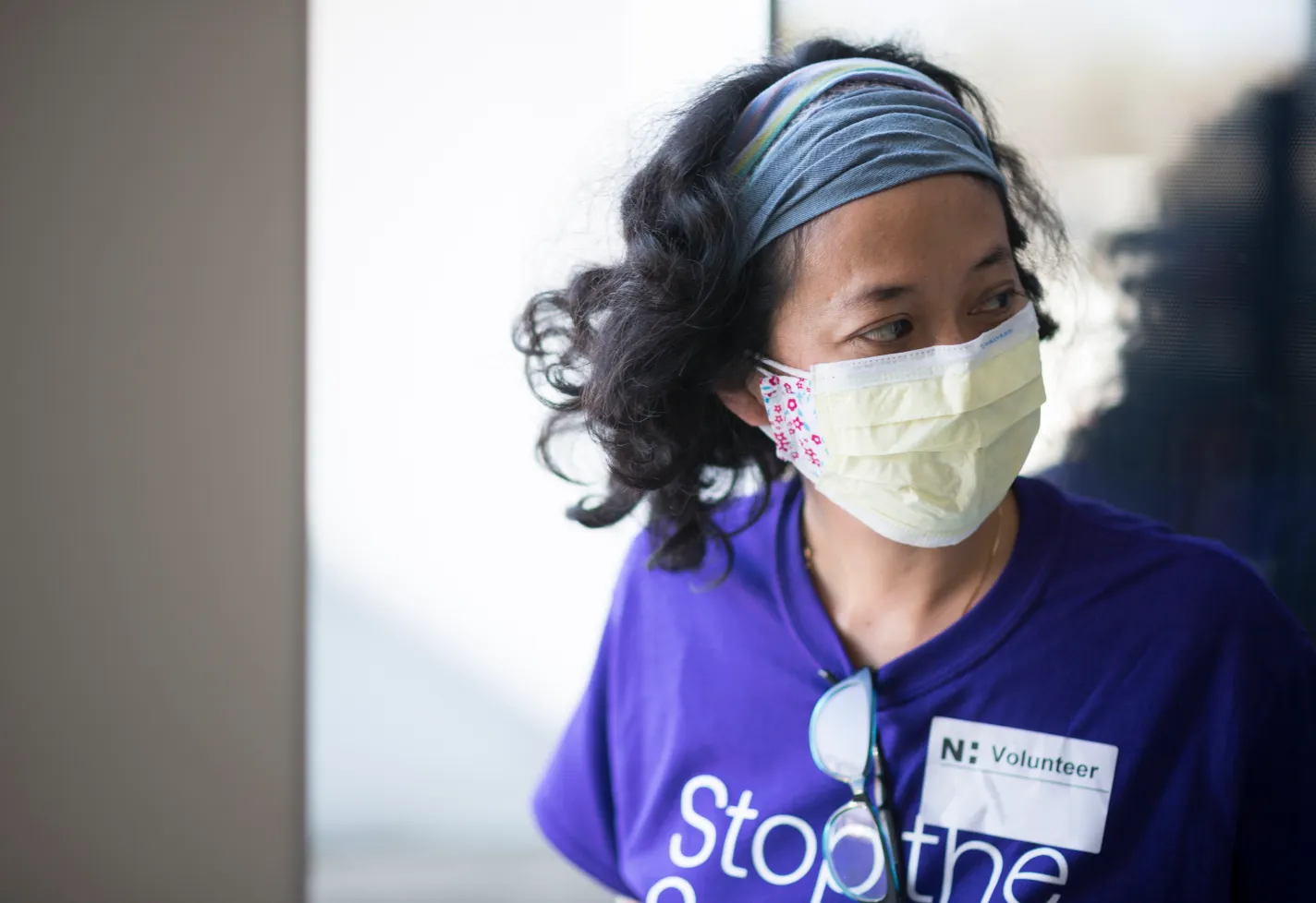 Masked woman volunteer at a clinic doorway Masked woman volunteer at a clinic doorway