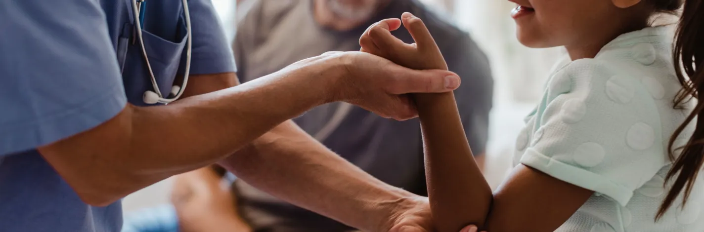 Young girl in examination room being seen by a doctor. 