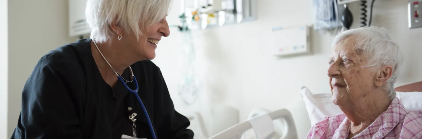 Nurse caring for a senior patient, both smiling