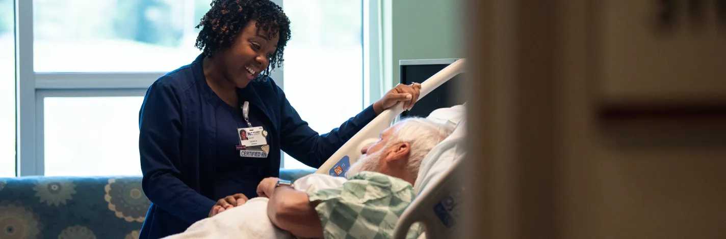 Certified registered nurse smiling and assisting elderly patient