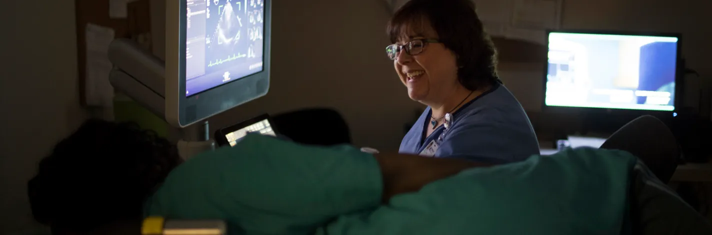 Smiling technician performing ultrasound on a patient