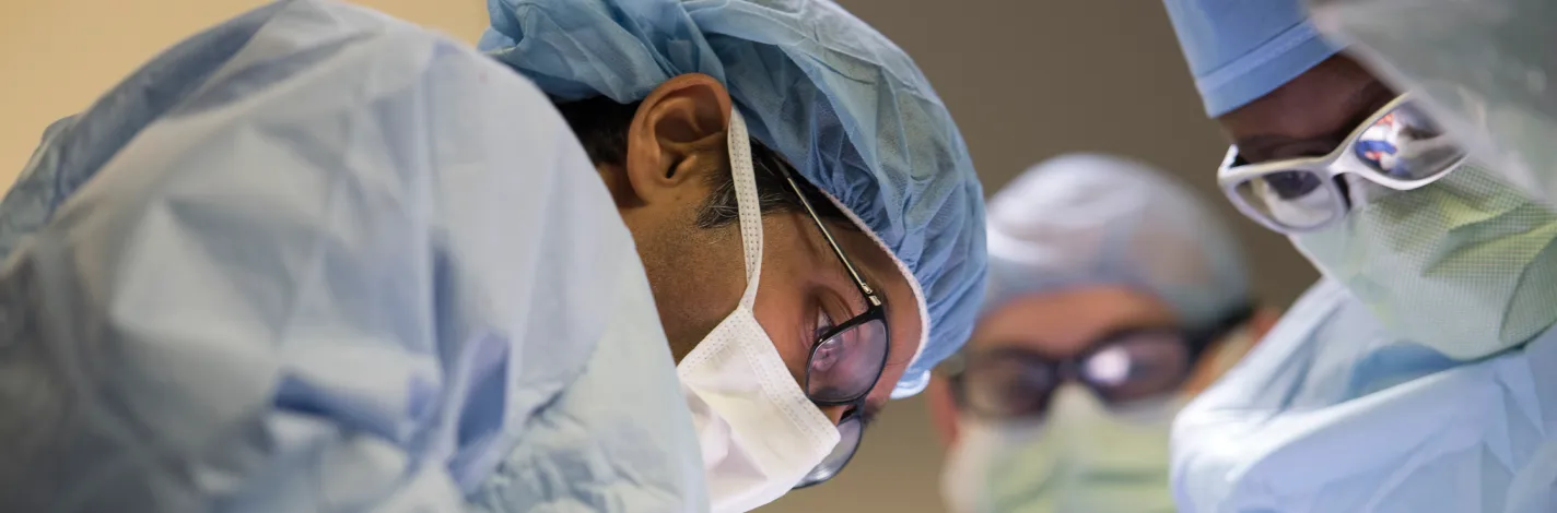 Three physicians performing surgery. 