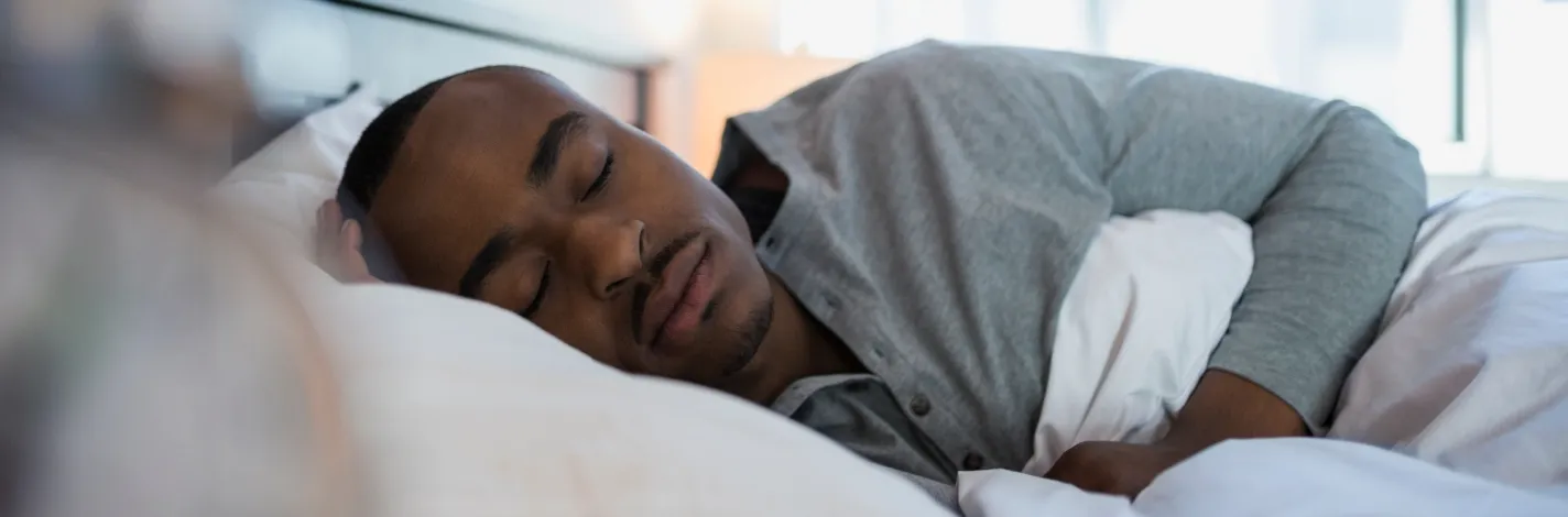 Adult man asleep in bed