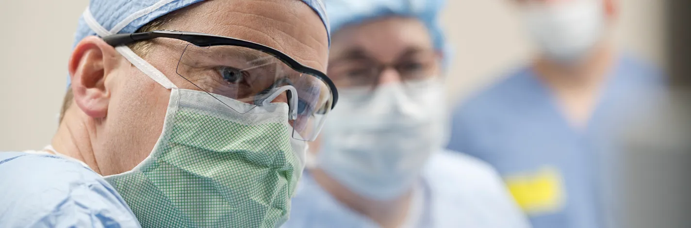 Two masked surgeons in an operating room 