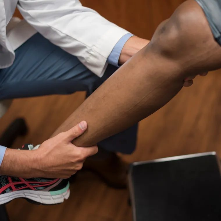 A healthcare provider giving patient a knee exam A healthcare provider giving patient a knee exam
