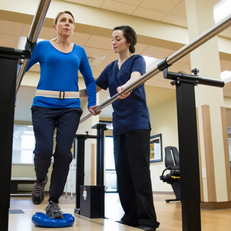 A Novant Health physical therapist is spotting a patient as they balance A Novant Health physical therapist is spotting a patient as they balance