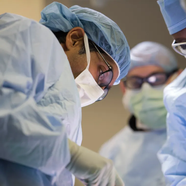 Group of healthcare providers in an operating room performing surgery. 