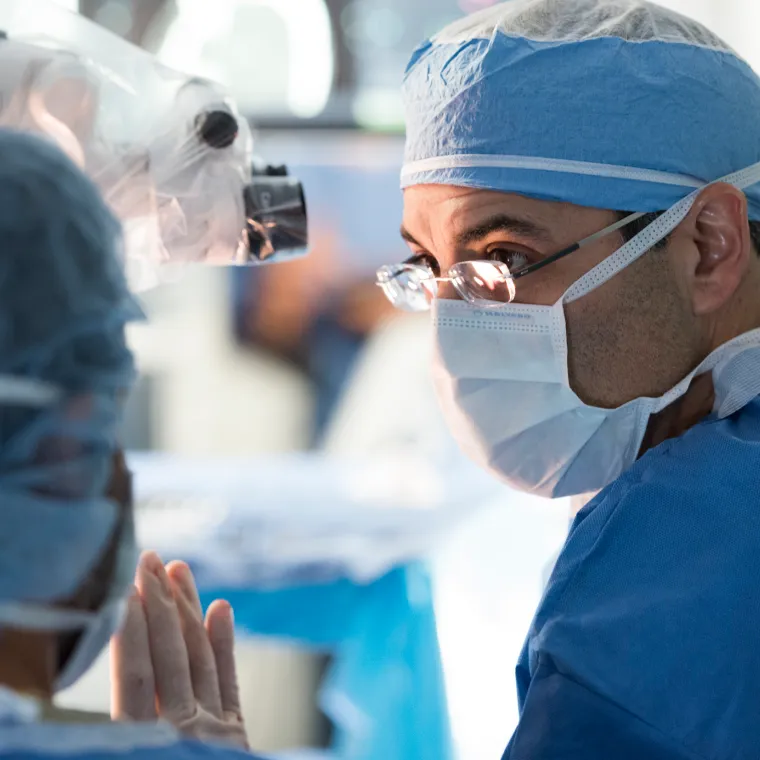 Two Novant Health doctors are in an operating room, during surgery, talking to each other. Two Novant Health doctors are in an operating room, during surgery, talking to each other.