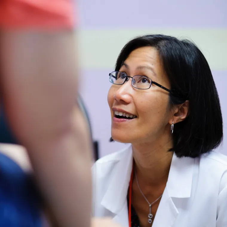 Woman provider looking up smiling as she exams a patient. Woman provider looking up smiling as she exams a patient.