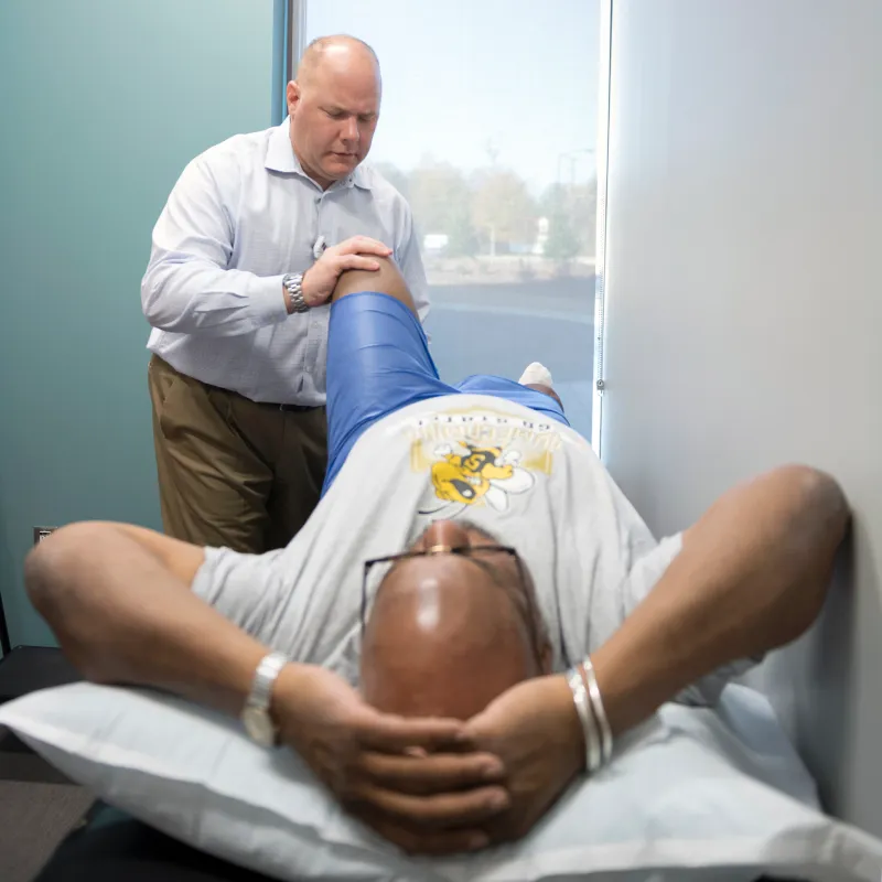 Dr. Craven is examining a patients knee Dr. Craven is examining a patients knee
