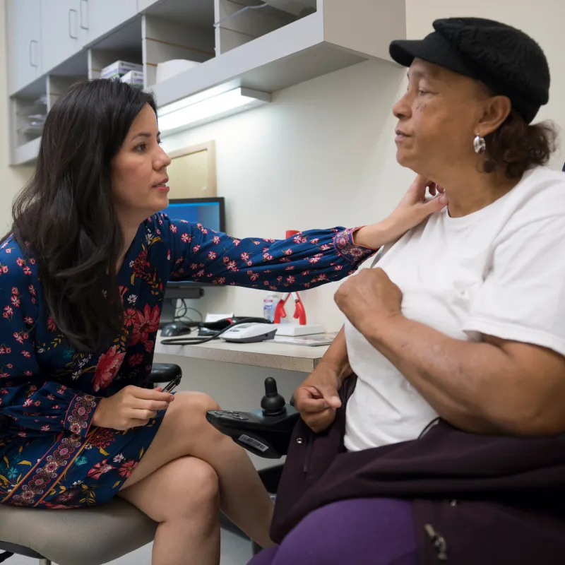 Dr. Kelso talking to a patient with her hand on the patient's shoulder