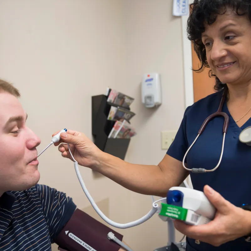 A nurse takes a boy's temperature