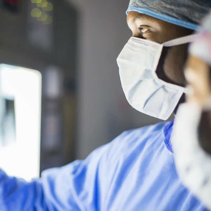 Two surgeons analyzing a patient’s medical scans during surgery.