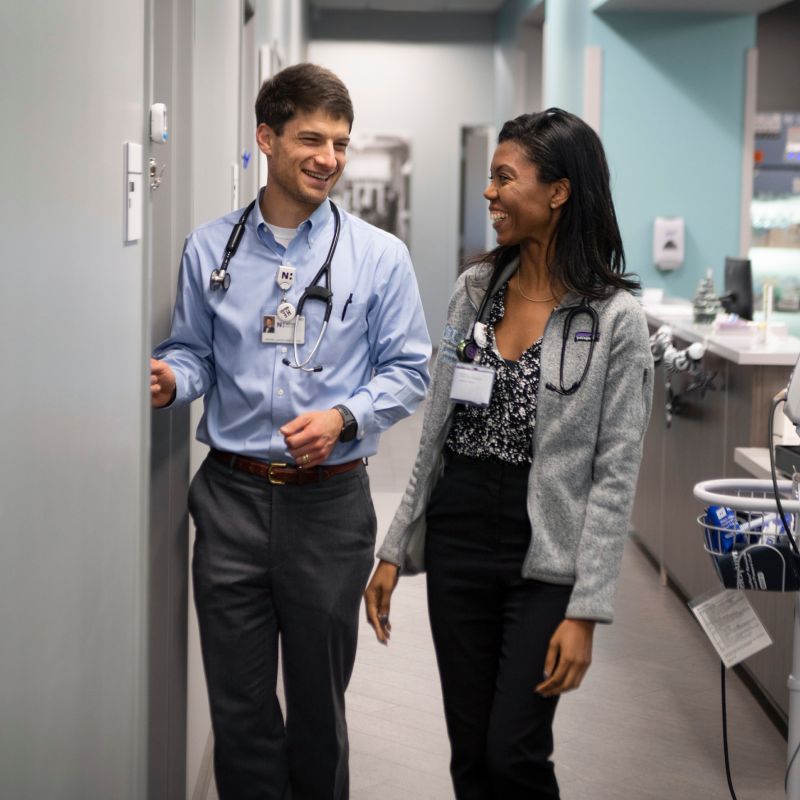 Dr David Baker and Dr Briana Stephens providers clinic hall laughing Dr David Baker and Dr Briana Stephens providers clinic hall laughing